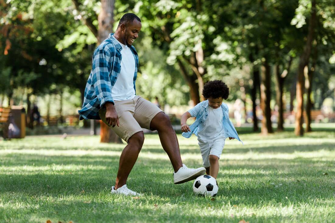 Picture of father and child playing soccer during mosquito season